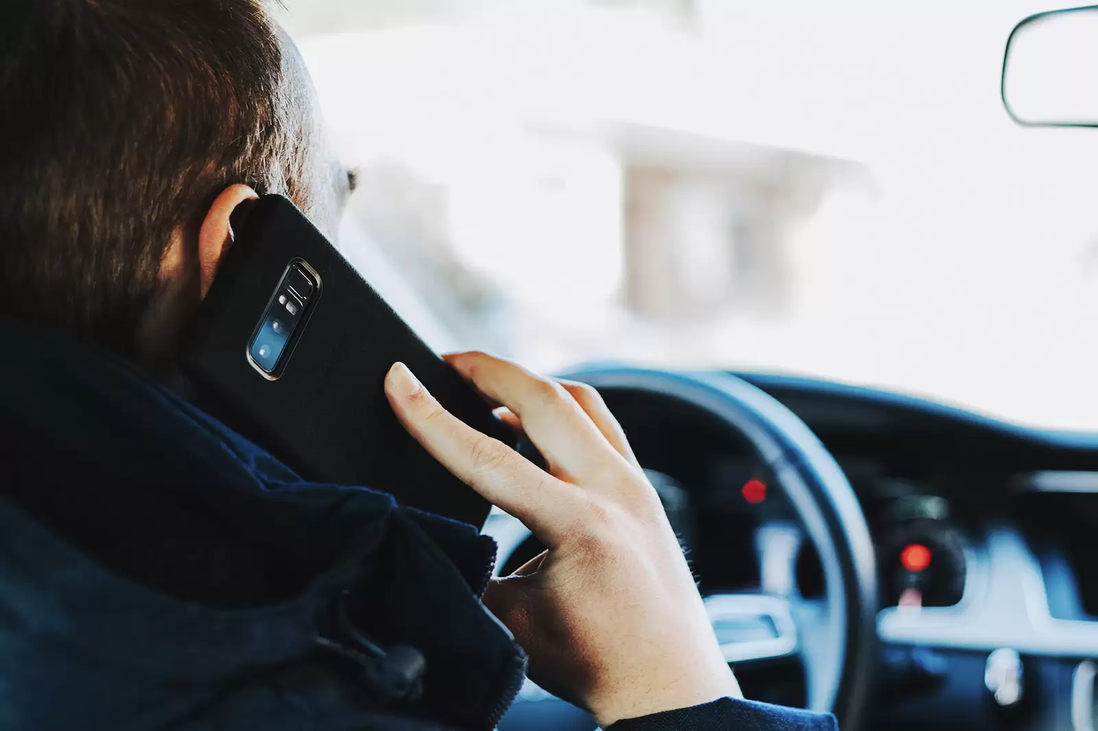 fahrende-person-telefoniert-während-der-fahrt-mit-smartphone
