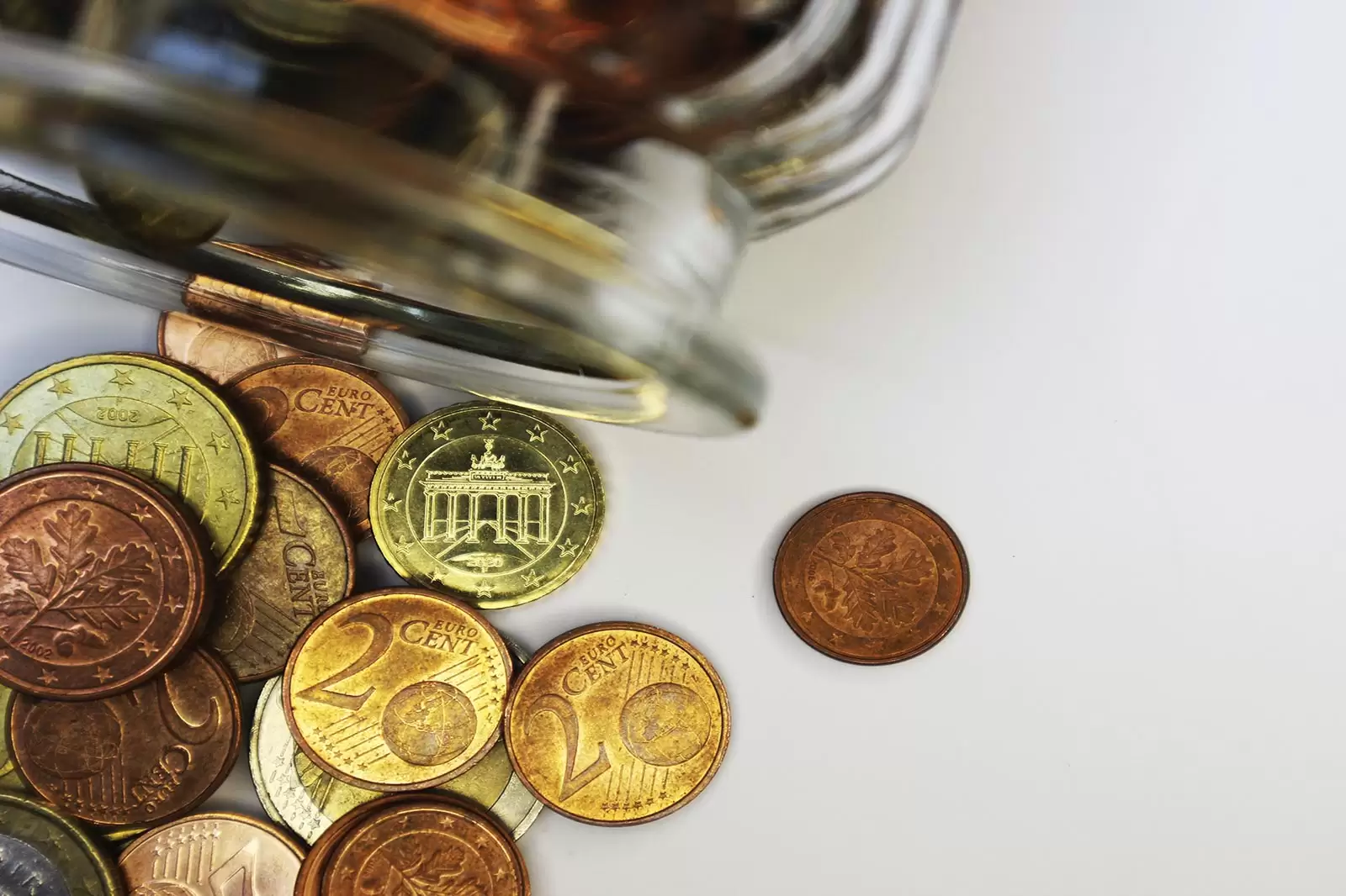 euromünzen-neben-einem-glasbehältnis