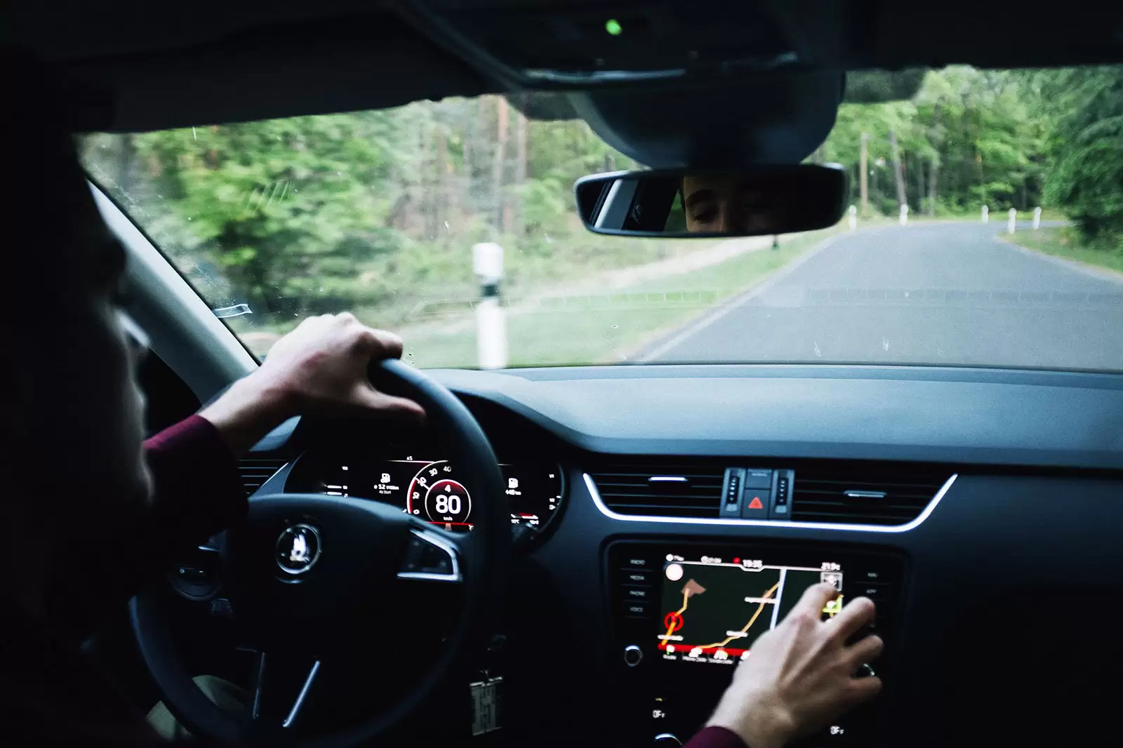 person-auf-beifahrersitz-bedient-navigationssystem-im-auto